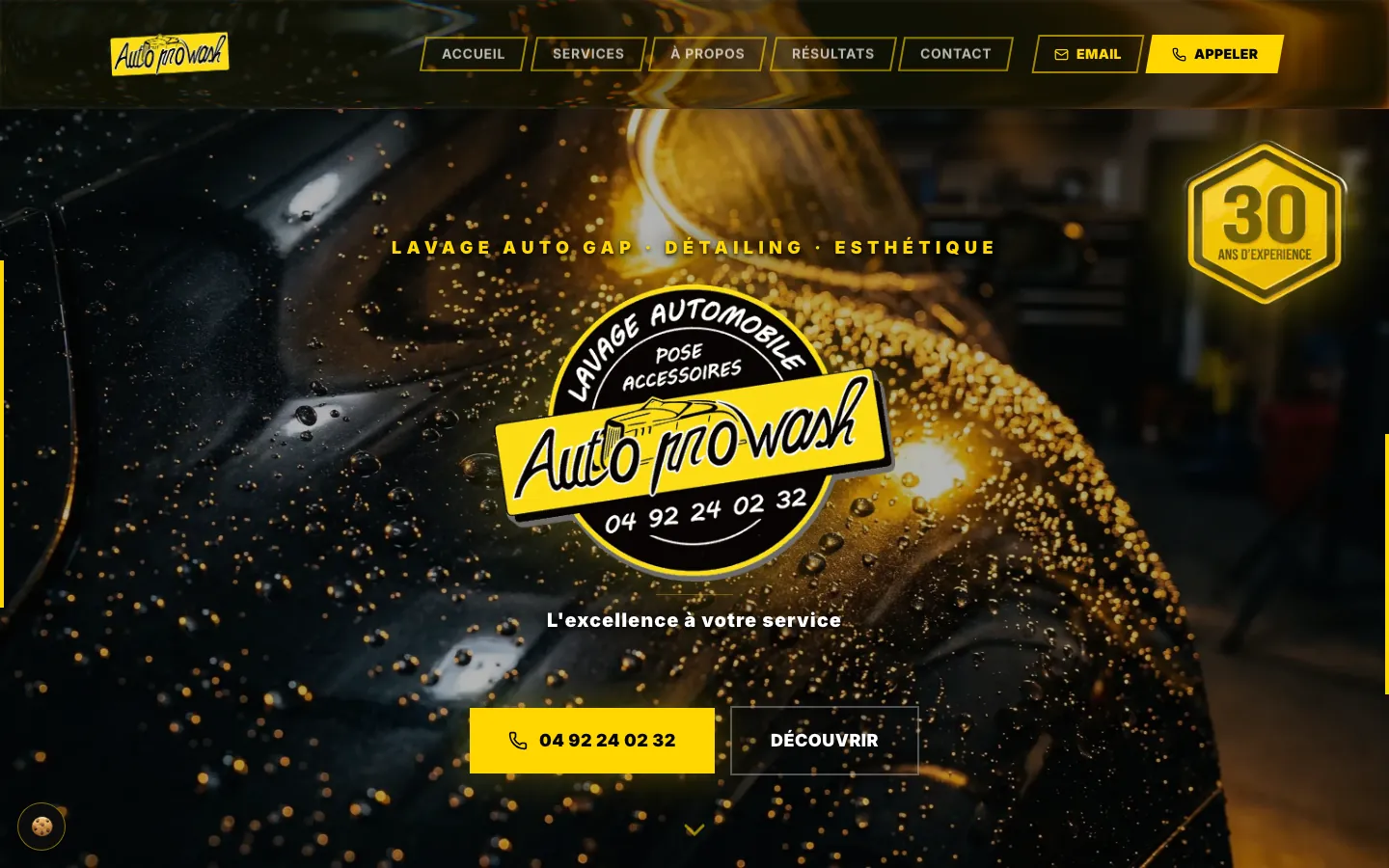 Page d'accueil du site Auto Pro Wash sur ordinateur : logo sur une carrosserie noire perlée d'eau, accroche et bouton d'appel